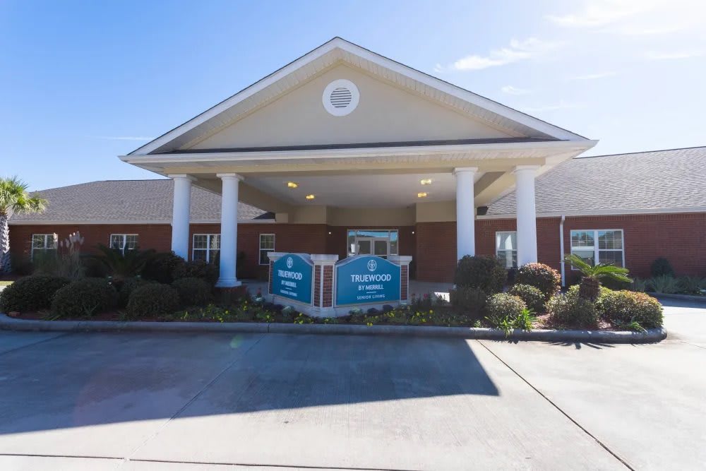 The image shows the entrance of a building with prominent columns and a pitched roof.