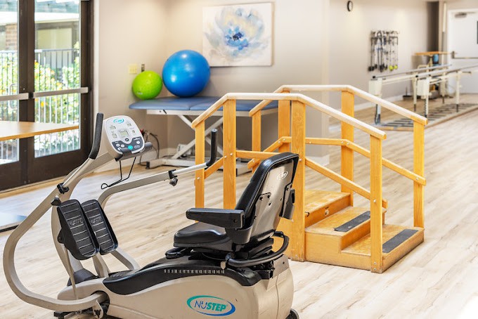 A physical therapy room equipped with exercise machines and fitness balls.