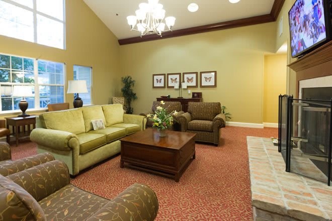 A cozy living room with a sofa, armchairs, and a chandelier.