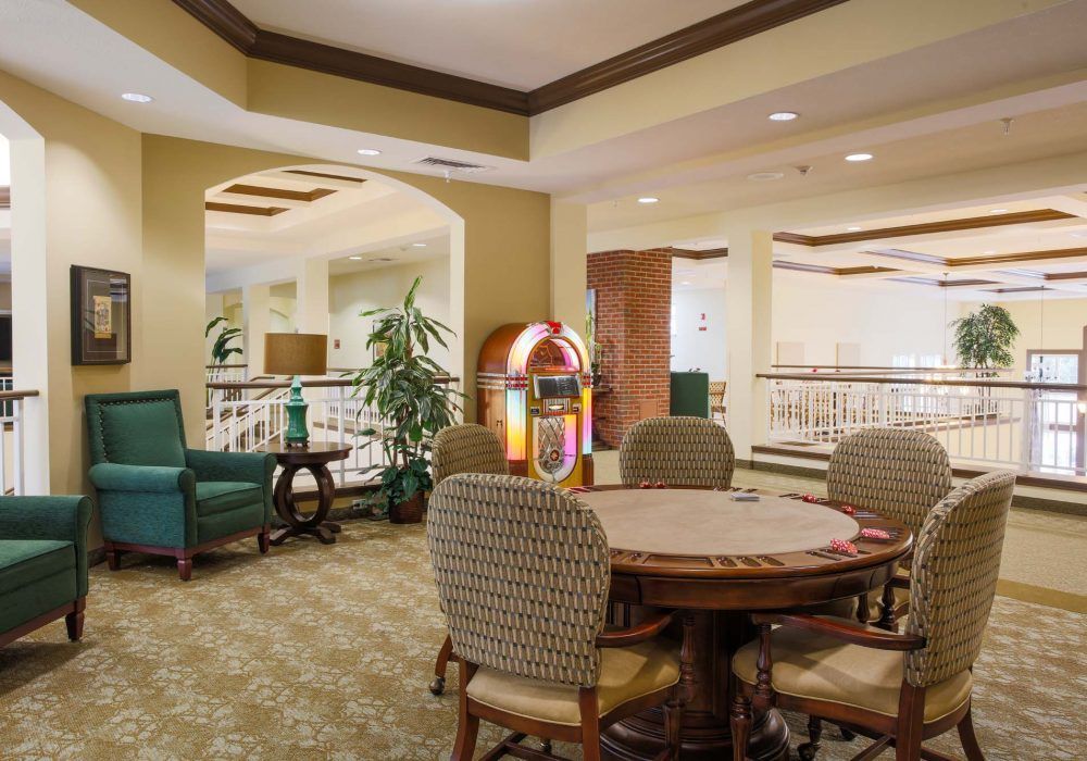 A cozy indoor seating area with a table, chairs, and a jukebox.
