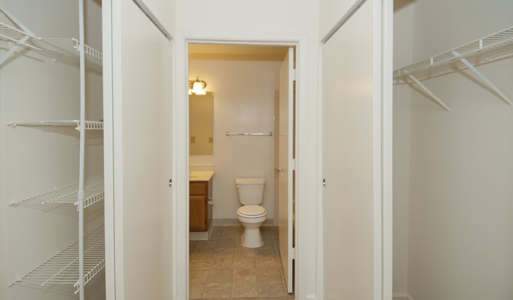 A clean and simple bathroom view with a toilet, sink, and mirror.