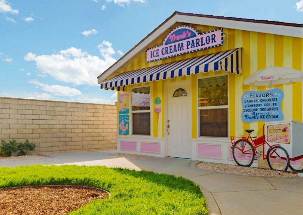 A colorful ice cream parlor with a vintage bicycle parked outside on a sunny day.