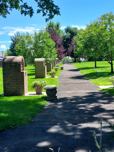 A serene pathway lined with trees and decorative planters, inviting visitors to explore the lush park.