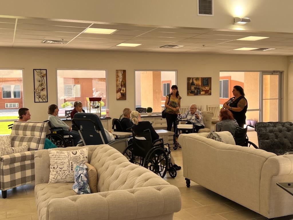 A group of people gathered indoors for a casual meeting or discussion in a community center setting.