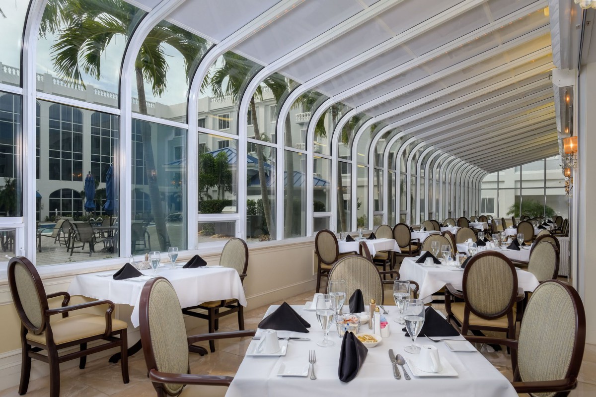 Elegant restaurant interior with a glass ceiling and natural light streaming in.