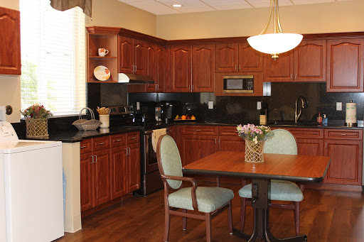 A modern kitchen featuring wooden cabinets and a cozy dining area.