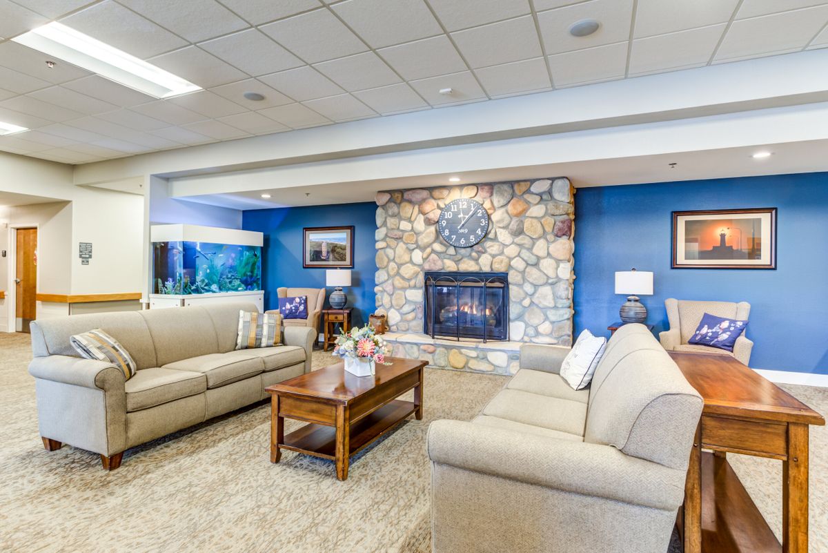 A cozy living room with comfortable sofas, a stone fireplace, and modern decor.