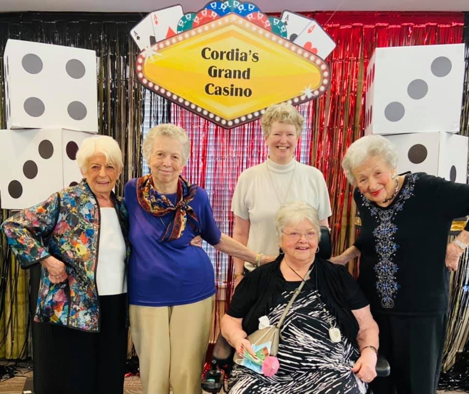 A group of seniors enjoying a casino-themed event with cheerful smiles.