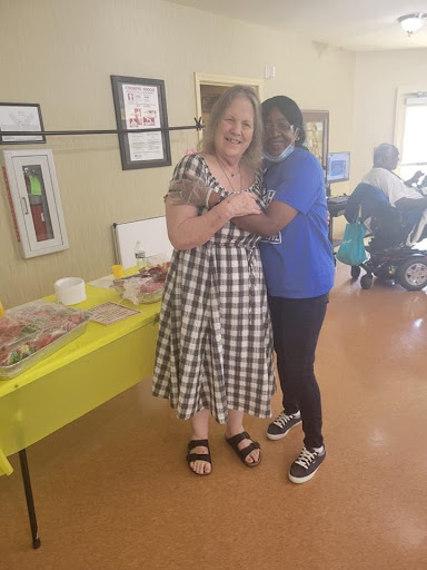 Two women sharing a joyful moment at a community event.