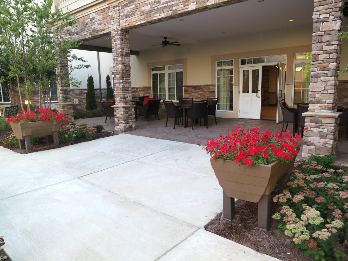 A cozy patio with outdoor seating and vibrant flowers in front of a building.
