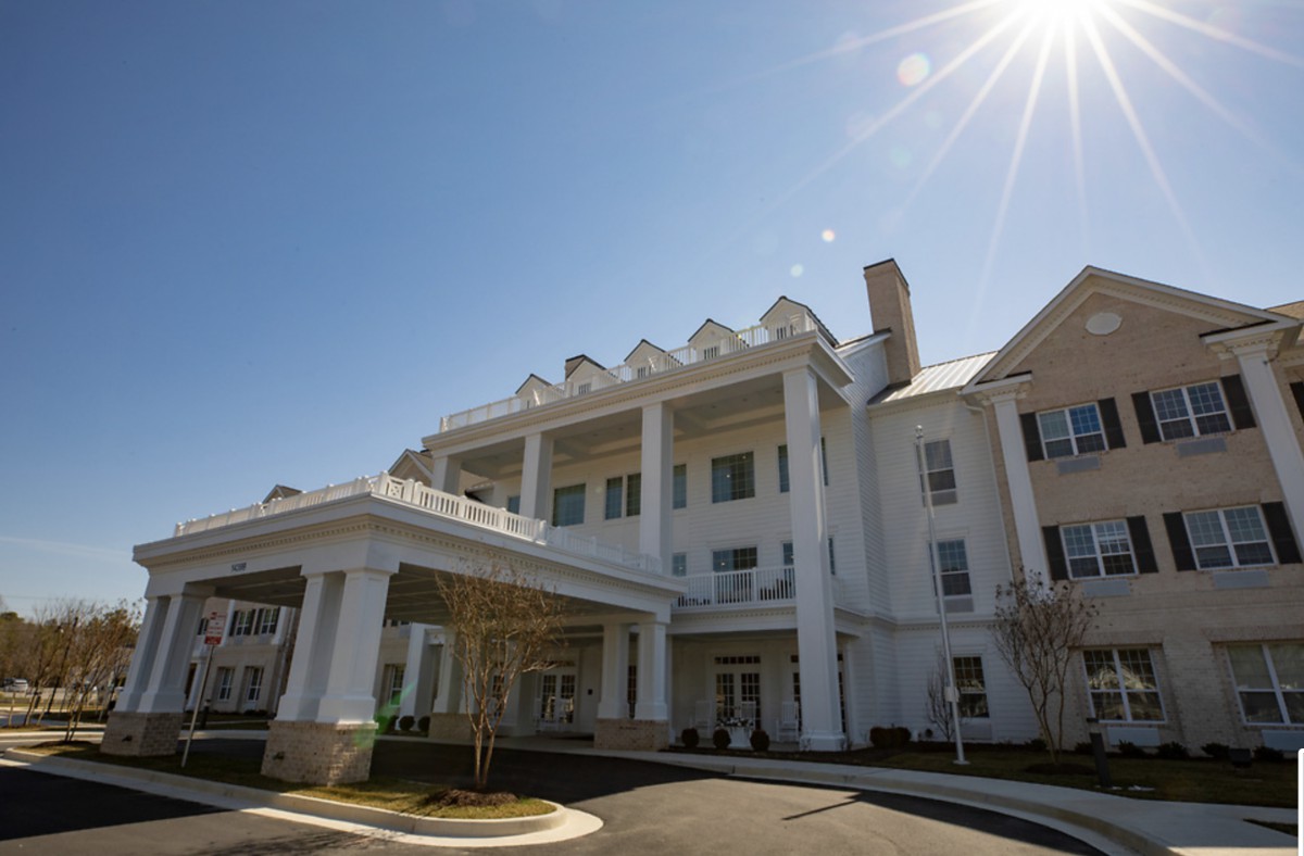 A large white building with columns under a bright sunny sky.