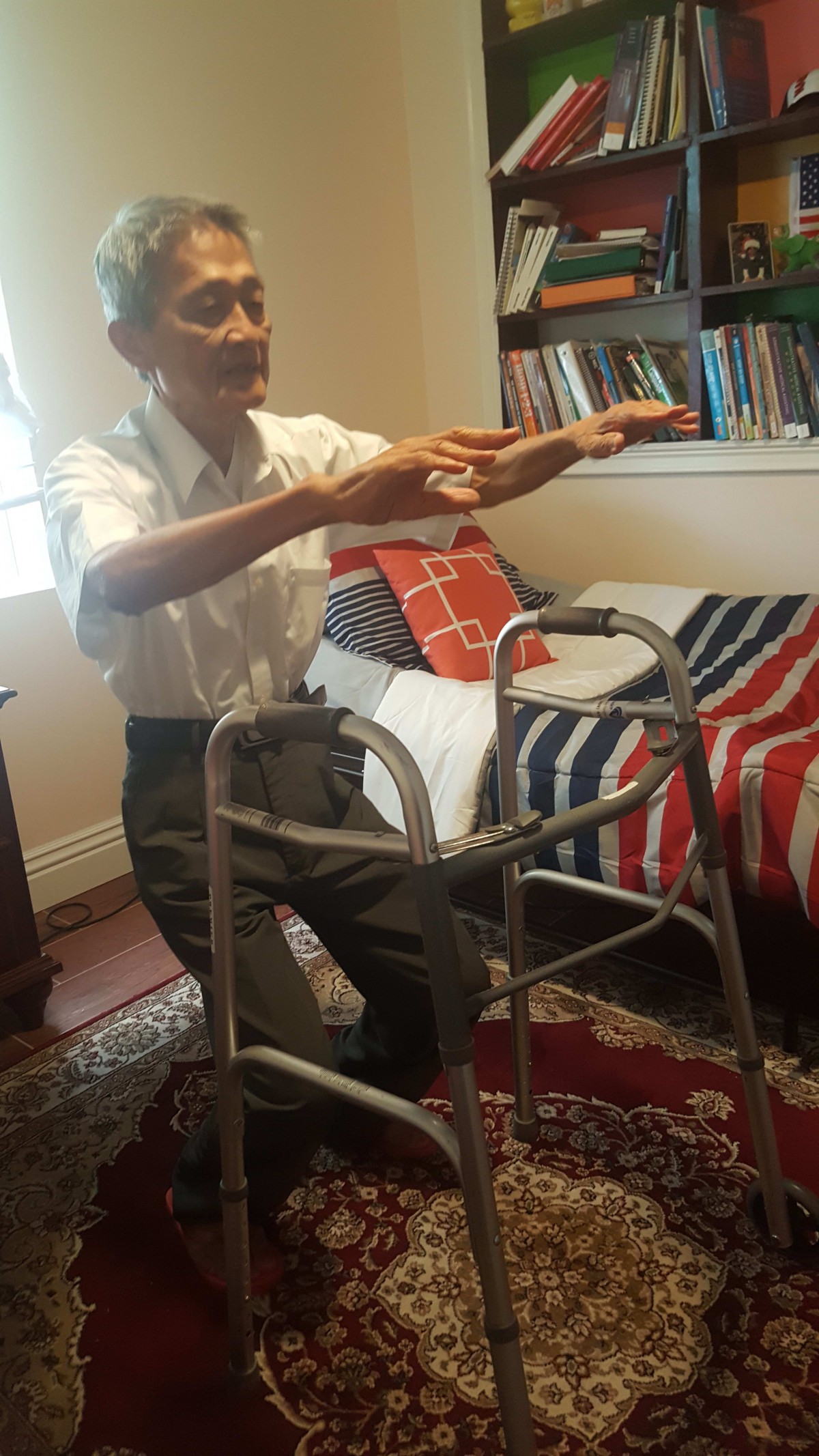 An elderly person using a walker for support while exercising at home.