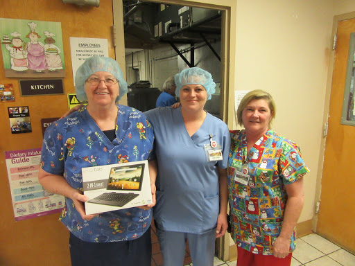 Three dedicated healthcare professionals posing together, celebrating a special moment.