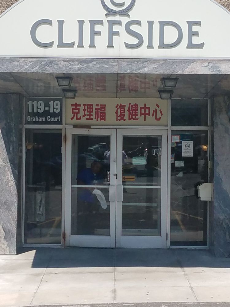 The entrance to a building with glass doors and multilingual signage.