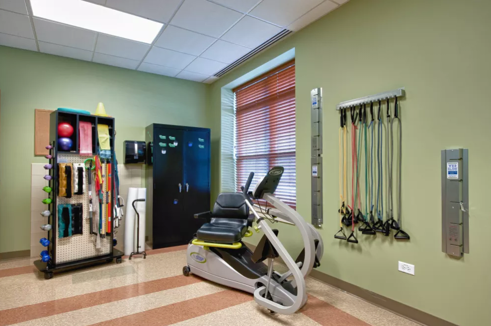 A well-equipped gym room featuring a stationary bike and resistance bands for fitness exercises.