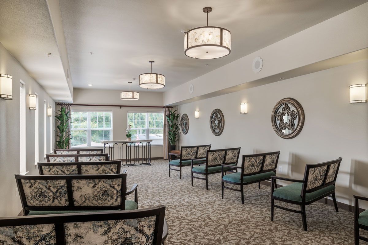 A well-lit interior seating area with decorative wall art and patterned chairs.