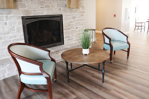 A cozy living room setup featuring elegant chairs and a rustic coffee table by the fireplace.