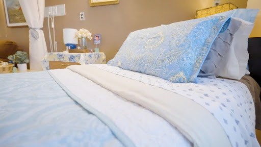 A cozy and inviting bedroom setup featuring soft blue bedding and decorative pillows.