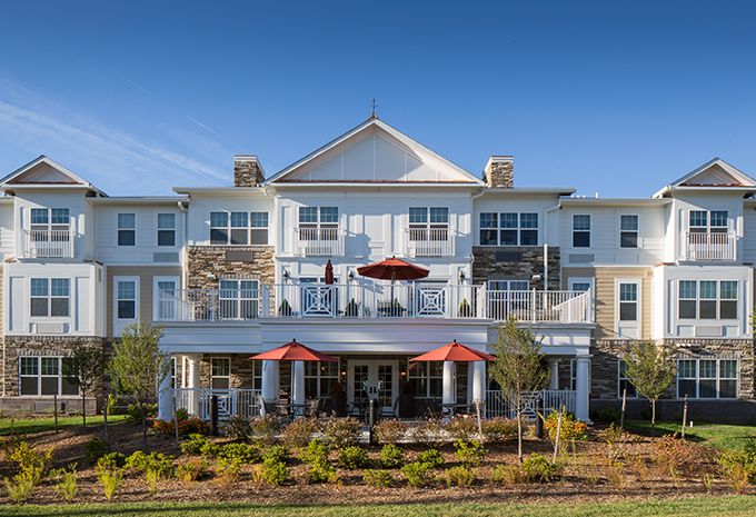 A modern residential building with outdoor seating and landscaped gardens.
