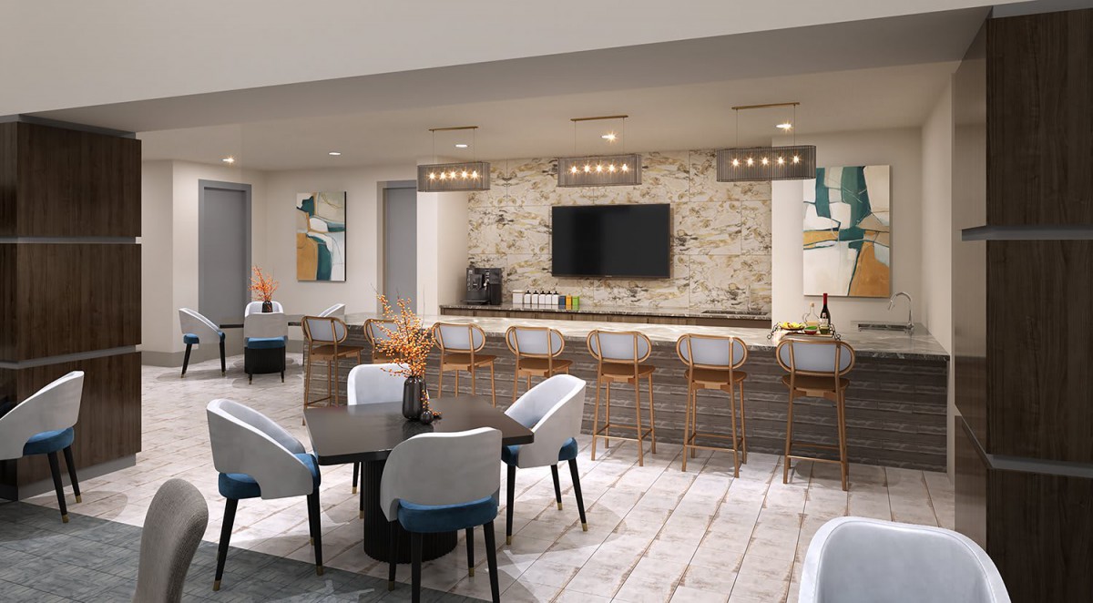 A modern kitchen and dining area featuring sleek bar stools, a large countertop, and contemporary lighting.