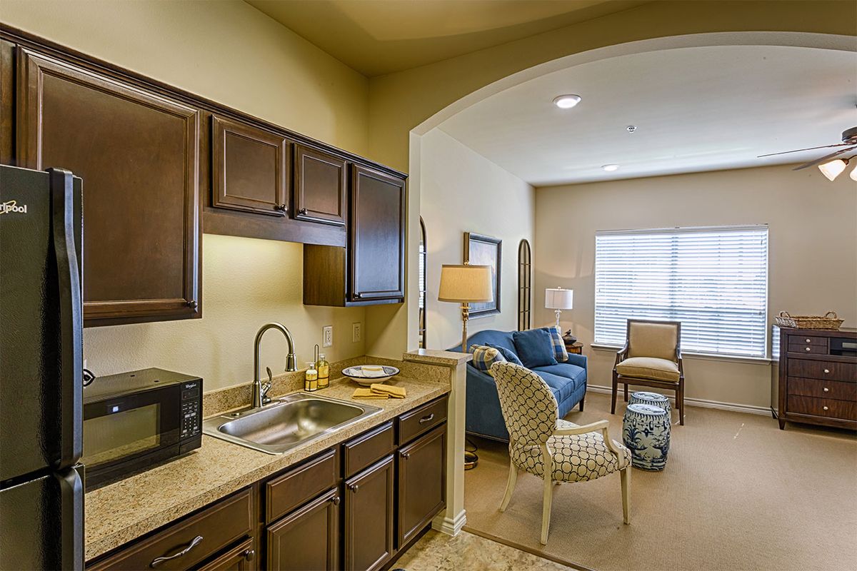 A cozy apartment interior featuring a small kitchen and an adjoining living area.