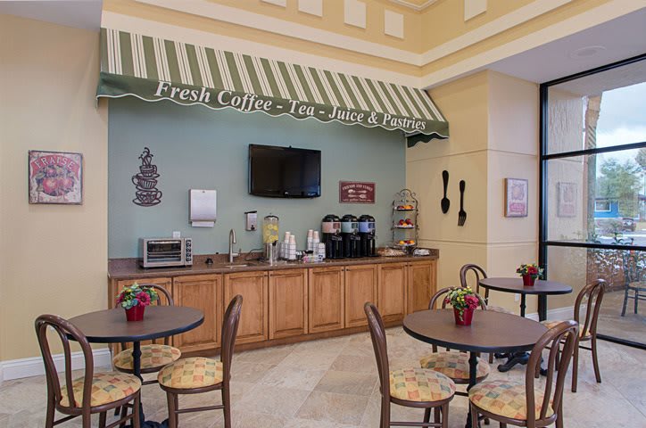 A cozy indoor cafe with a self-service coffee station and seating area.