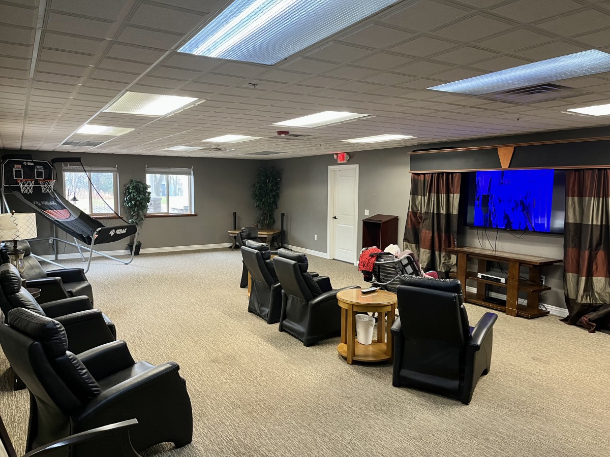 A spacious home theater room with comfortable seating and a large television.
