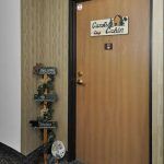 A wooden door with a cozy cabin sign and decorative items.