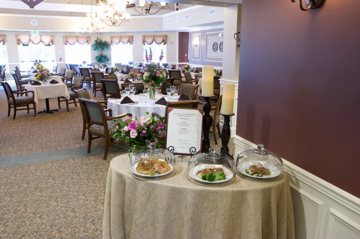 An elegant dining area with a food display table at the entrance, set for guests.