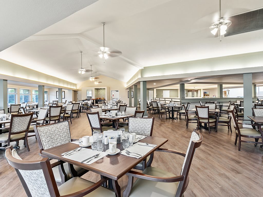 A spacious and elegantly arranged dining area with neatly set tables and comfortable seating.