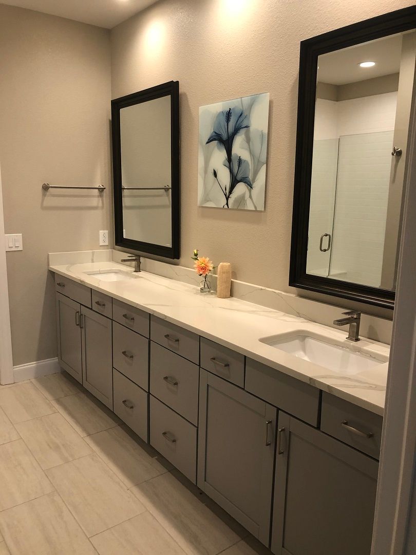A modern bathroom featuring a double sink vanity with large mirrors and neutral decor.