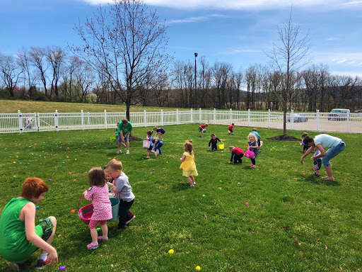 Children enjoying an Easter egg hunt on a sunny spring day.