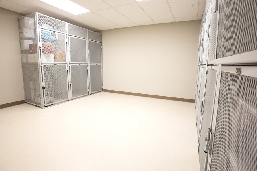An empty room with metal kennels lining the walls.