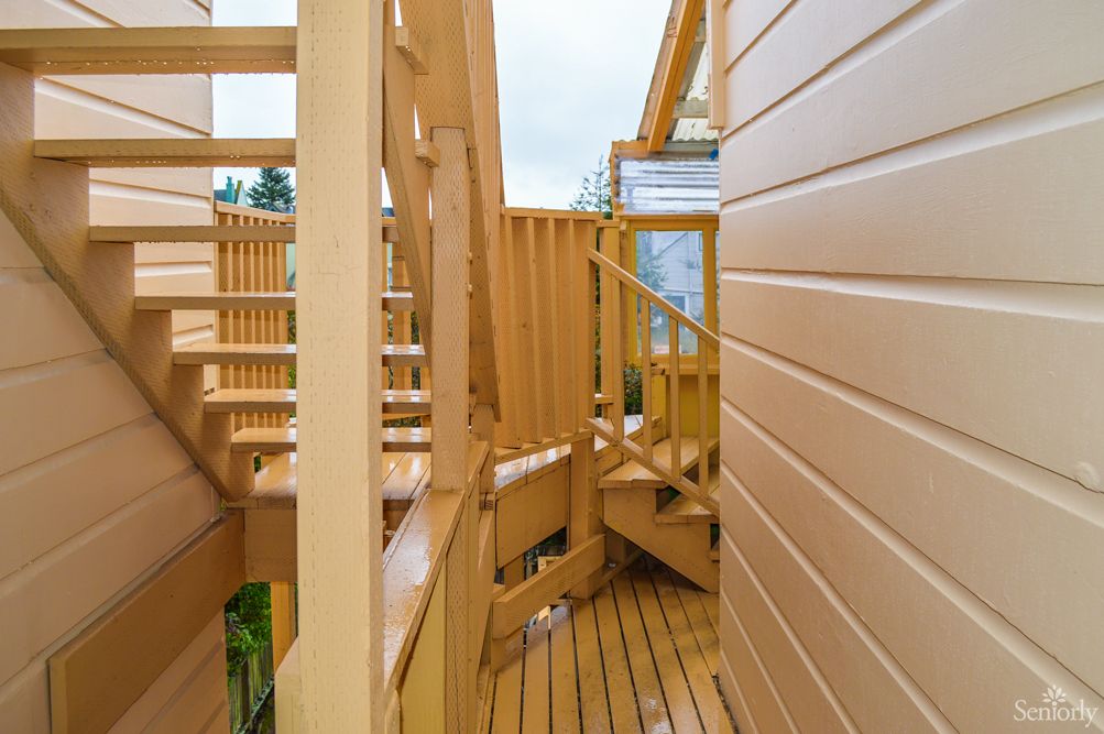 A wooden deck with stairs and railings leading to an outdoor area.
