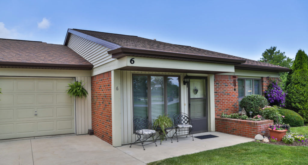 A cozy single-story house with a small front patio area and brick exterior.