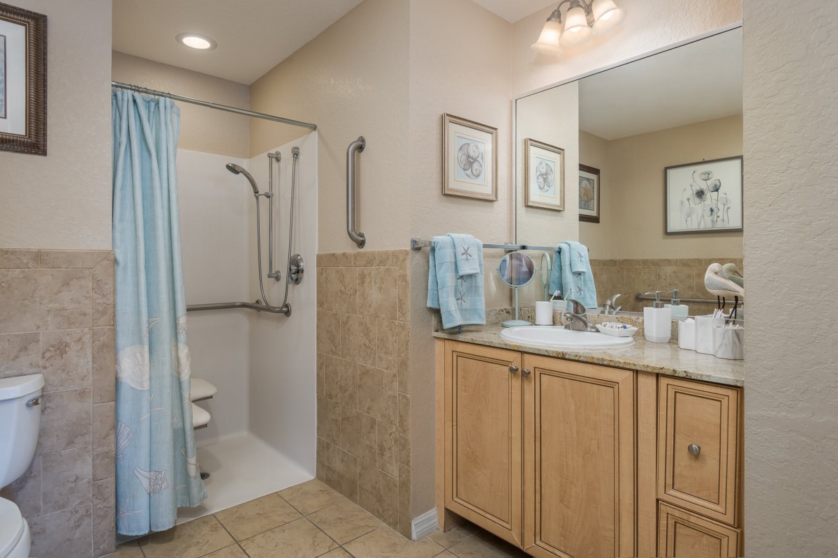 A modern bathroom with a walk-in shower and a vanity with dual sinks.