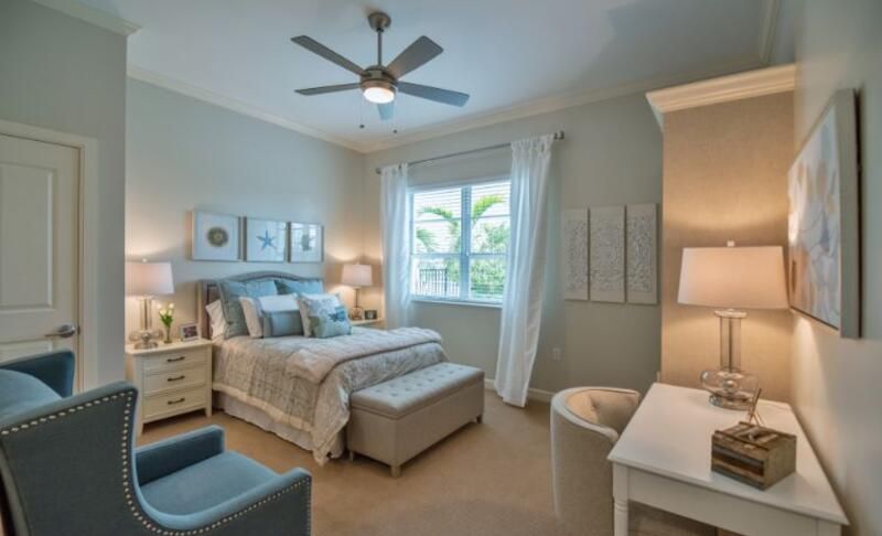 A well-decorated bedroom featuring a comfortable bed, elegant lighting, and soothing color palette.