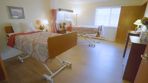 A tranquil hospital room featuring two adjustable patient beds.