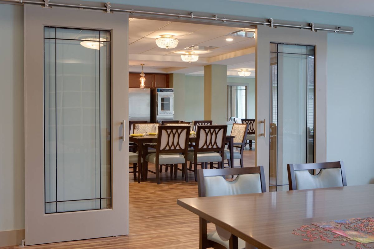 A modern dining area with elegant furniture and sliding glass doors.