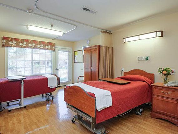 A clean and organized hospital room with two patient beds.