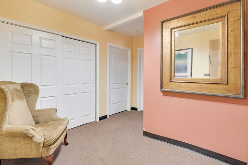 A welcoming hallway featuring a decorative mirror and multiple doors leading to different rooms.