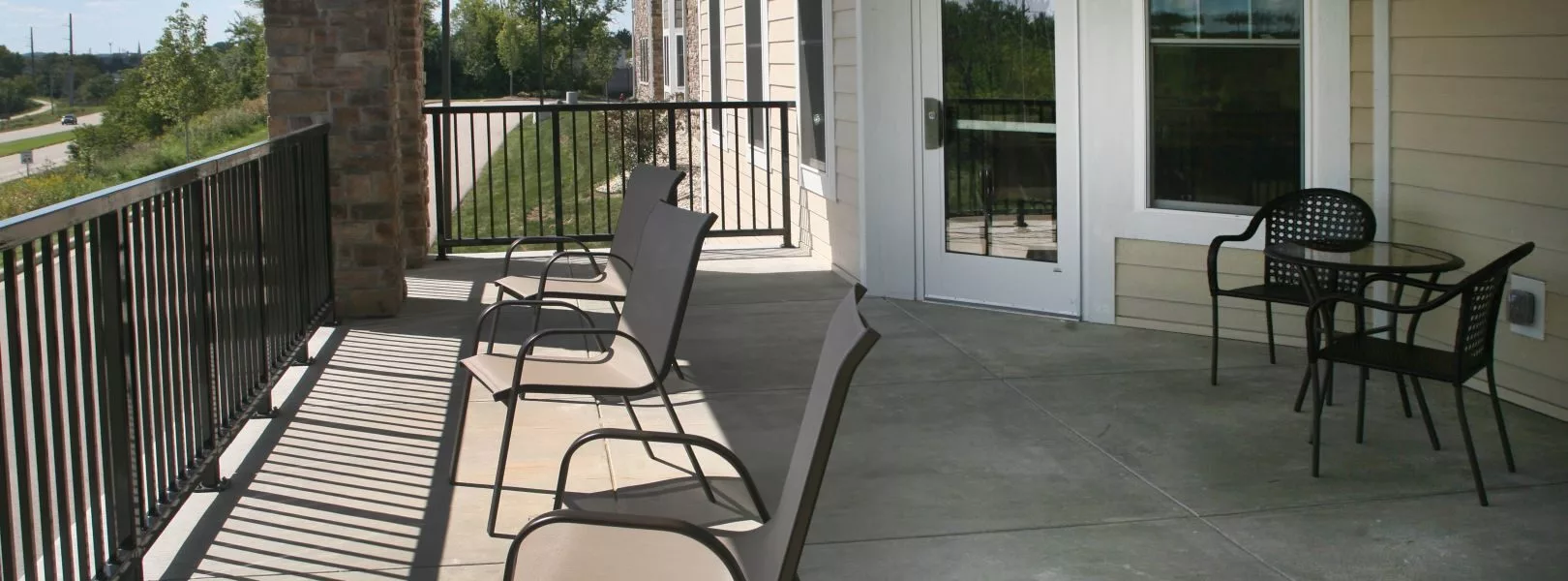 Outdoor patio area with chairs lined up on a balcony.