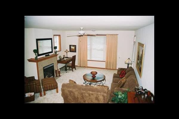 A cozy living room with a fireplace, sofa, and coffee table, complemented by a television and elegant decor.