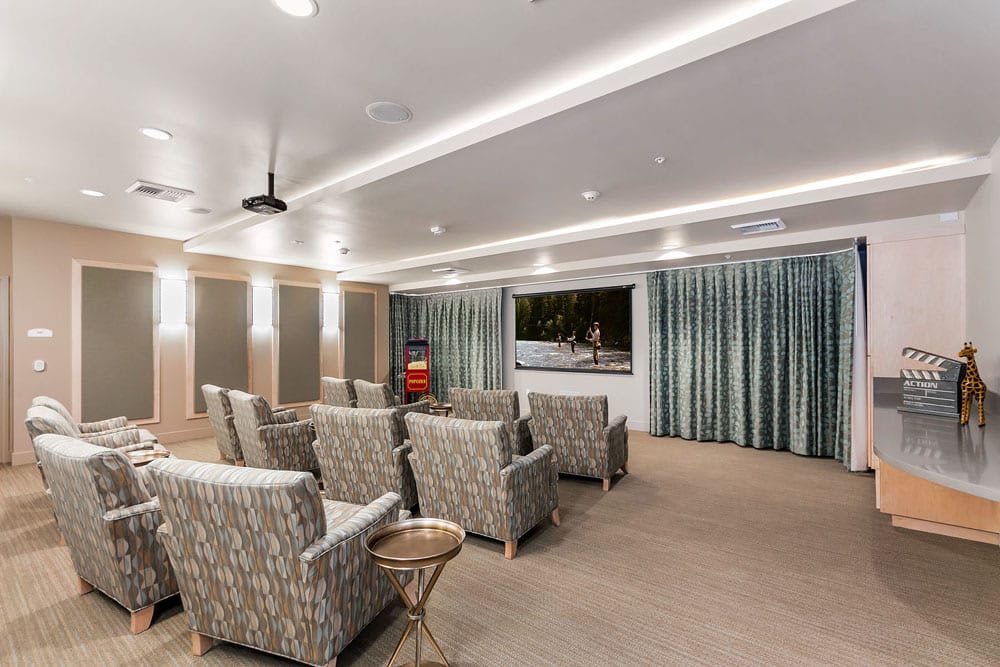 A well-designed home theater room featuring comfortable seating and a large screen.