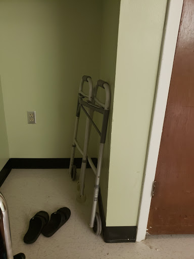 A small corner of a room featuring a walker and some slippers.