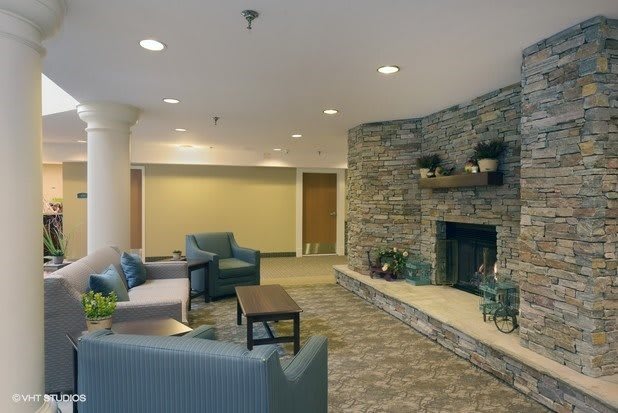 A cozy living room with a stone fireplace and comfortable seating.