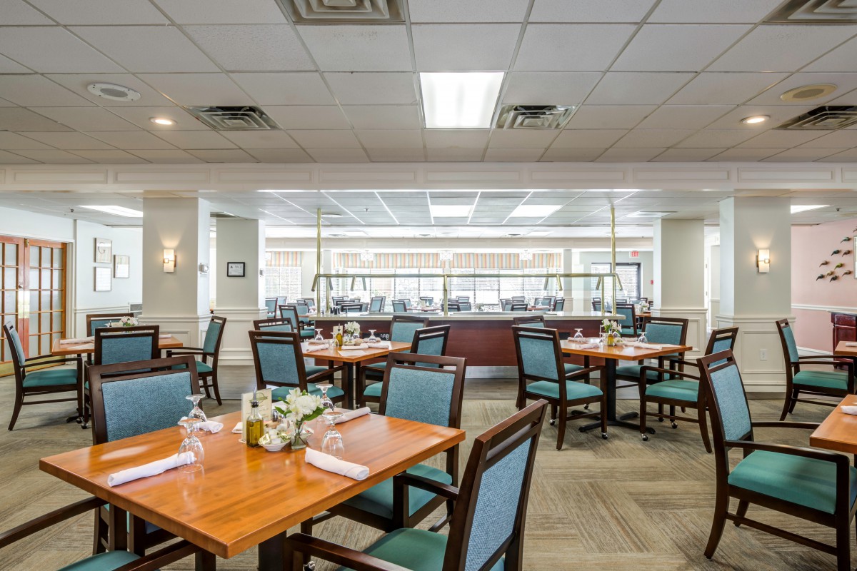An empty dining room with neatly arranged tables and chairs.
