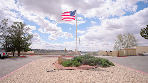 A vibrant American flag waving against a backdrop of clouds and a vast sky.
