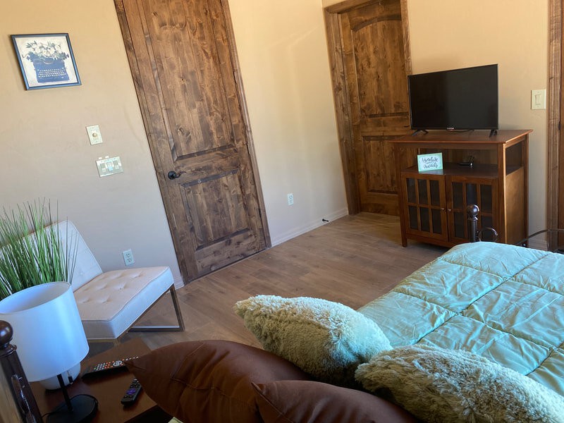 A cozy living room with wooden doors, a television, and comfortable seating.