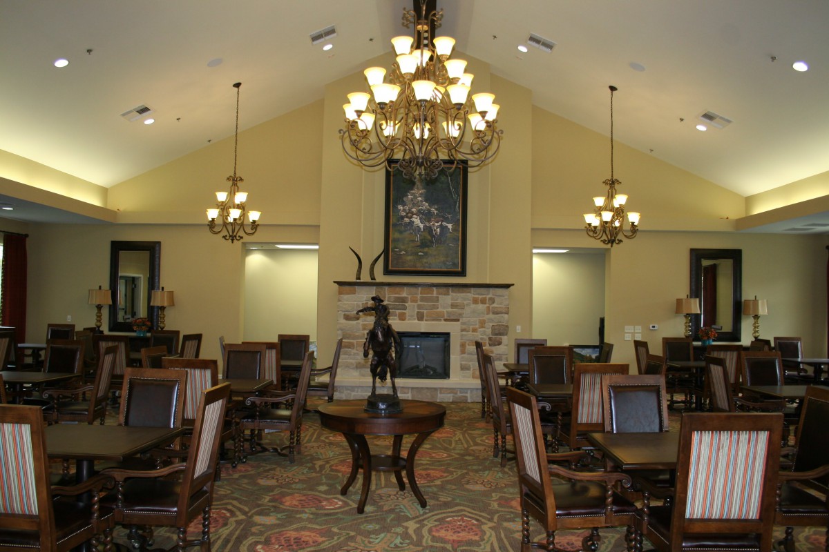 An elegant dining room with chandeliers and a fireplace.